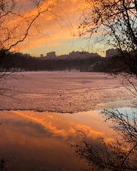 Scenic view of lake against orange sky during winter