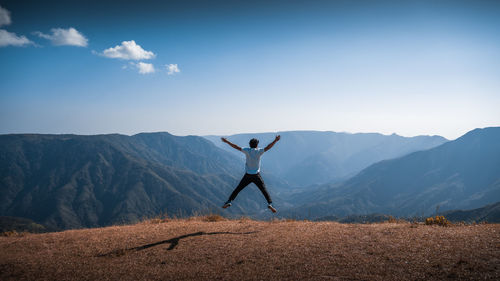 Man jumping against mountains