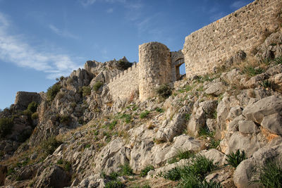 Low angle view of castle on mountain against sky