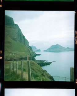 Scenic view of sea and mountains against sky