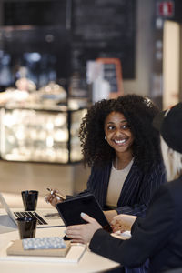 Female coworkers talking in cafe