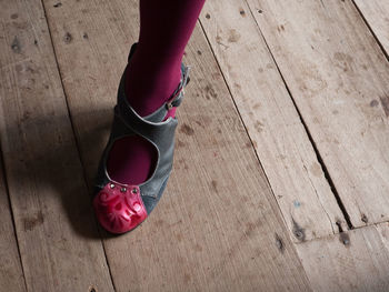 Low section of woman standing on hardwood floor