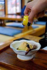 Close-up of hand pouring food on table