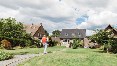 Woman with son walking on field in yard