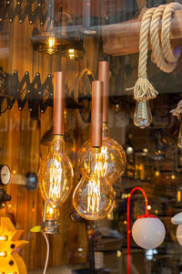 Close-up of illuminated light bulbs hanging at store