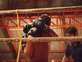 Rear view of shirtless man in cage