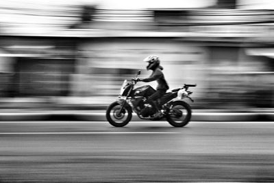 Side view of a person riding motorcycle on road