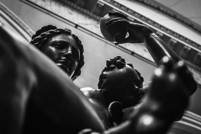 Low angle view of man holding sculpture