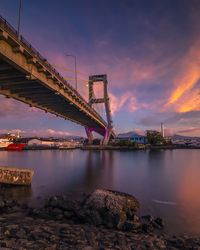 Bridge over river in city against sky