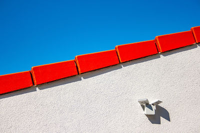 Low angle view of white wall against blue sky