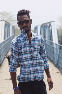 Portrait of young man wearing sunglasses standing outdoors