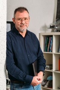 Portrait of smiling man leaning against wall