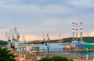 Crane by building against sky