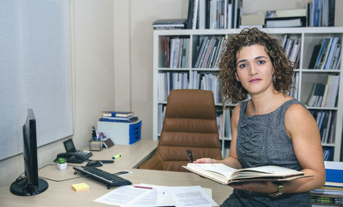 Young woman sitting on book