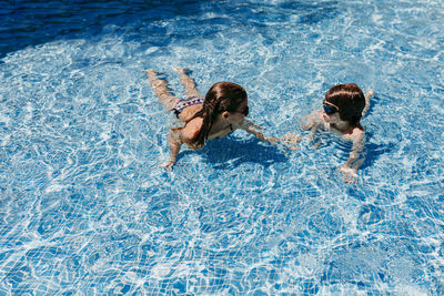 High angle view of two people swimming in pool