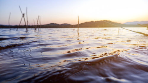 Surface level of sea against sky during sunset