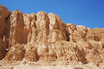 Low angle view of rock formation against clear blue sky