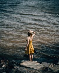 Rear view of woman standing in sea