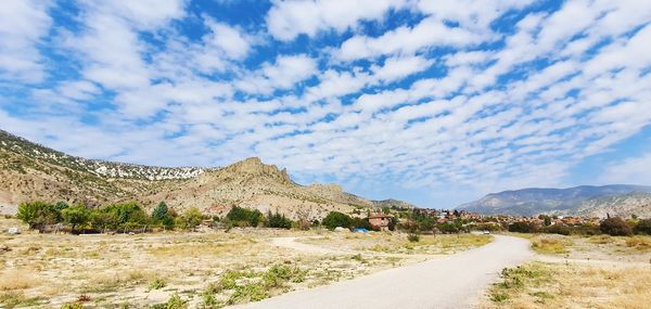 Road by mountain against sky