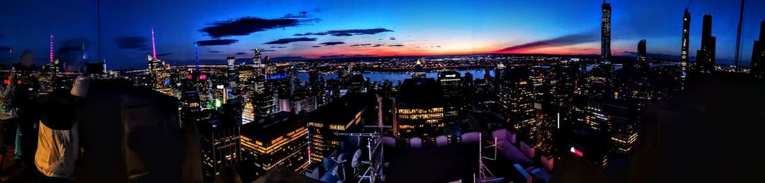 Panoramic view of illuminated buildings against sky at night