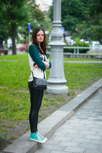 Portrait of smiling woman standing on footpath