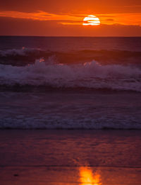 Scenic view of sea against orange sky