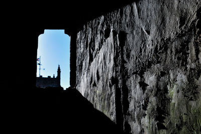 Low angle view of silhouette rock formation against sky