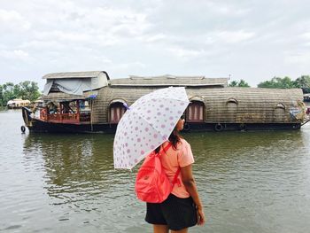 Woman on boat in river against sky