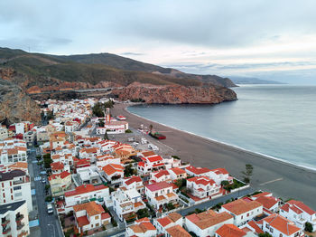 High angle view of townscape by sea against sky