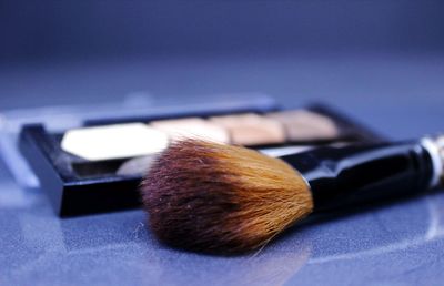 Close-up of make up brush and eye shadow palette 