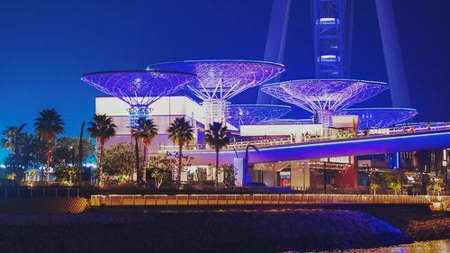 Illuminated bridge against sky at night