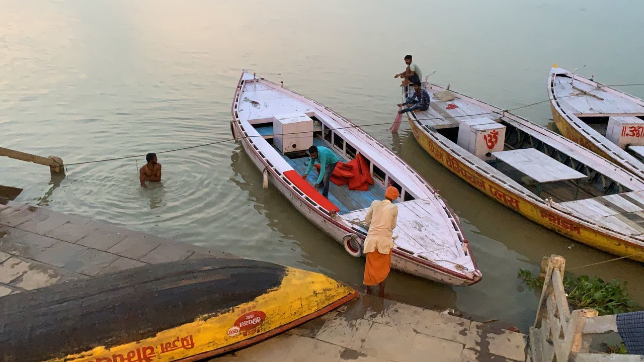 HIGH ANGLE VIEW OF PEOPLE SITTING ON BOAT