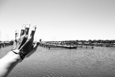 Close-up of hand holding water against clear sky