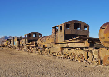 Abandoned train against clear blue sky