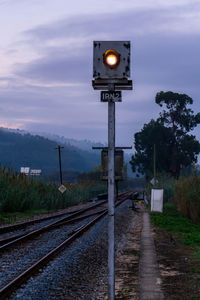 Landscape with railway semaphore, eucalyptus tree and railway tracks against hills in fog