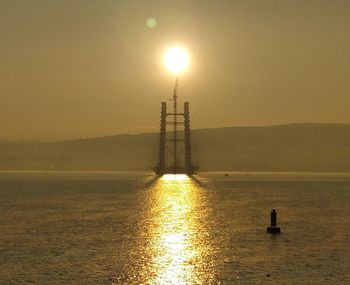 Silhouette sailboat on sea against sky during sunset