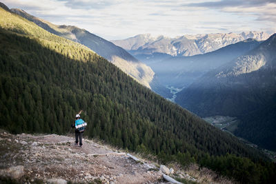 A young girl walking on a trail into the mountains