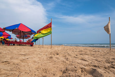 Multi colored umbrellas on beach against sky