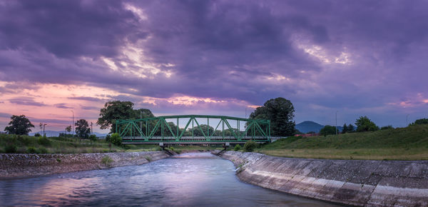 Bridge over river against sky during sunset