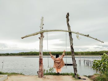 A woman sat on the swing by the sea