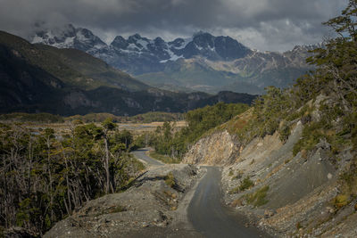 Scenic view of road by mountains against sky