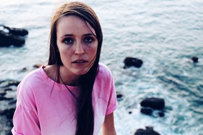 Portrait of young woman standing at beach