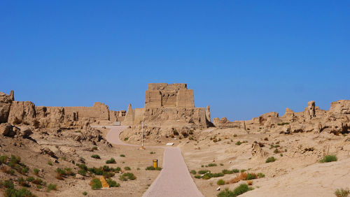 Panoramic view of desert against clear blue sky