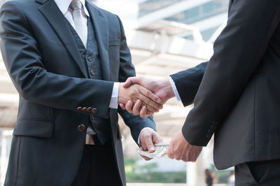 Midsection of couple holding hands