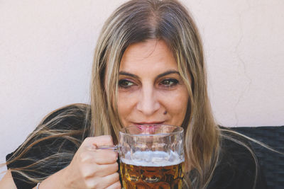 Smiling mature woman drinking beer