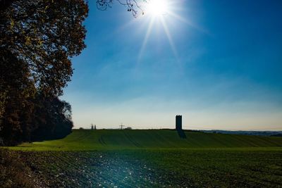 Scenic view of field against bright sun