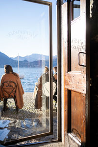 Rear view of woman looking through window