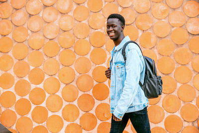 Portrait of boy standing against wall