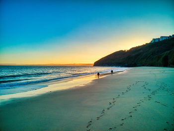 Scenic view of beach against sky during sunset