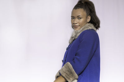 Side view of woman looking away against white background